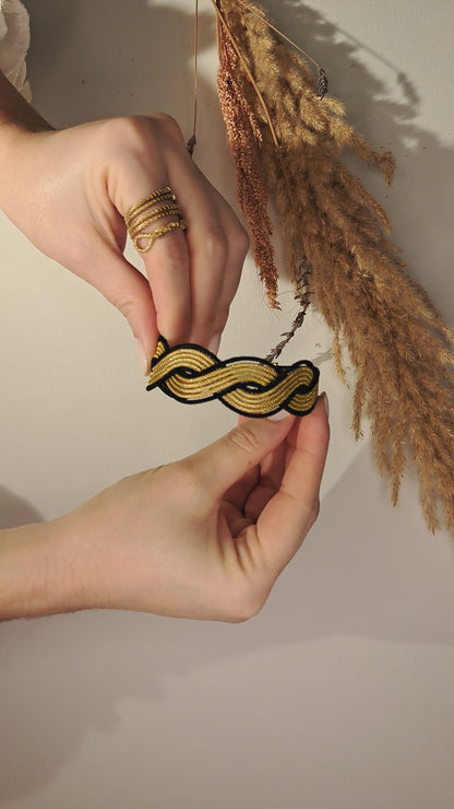 Armband met zwart en goudkleurig vlechtwerk van Capim Dourado, Braziliaans handgemaakt sieraad