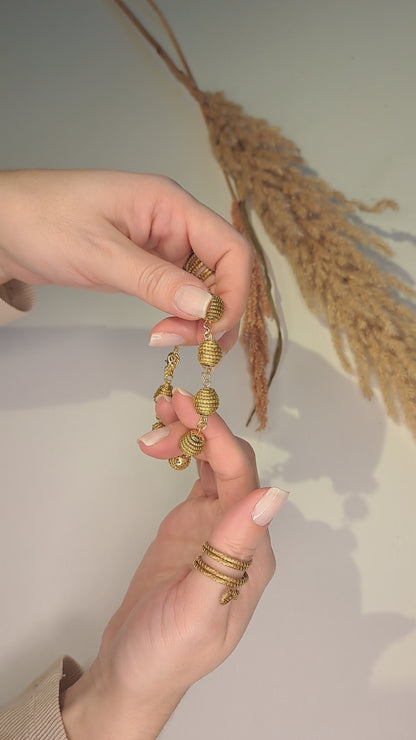 Pulsera delicada de bolas trenzadas en Capim Dourado, joya artesanal de Brasil