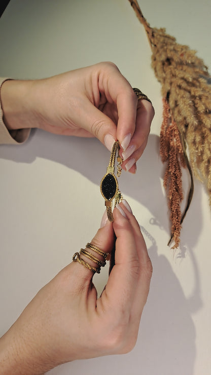 Pulseira fina de Capim Dourado (ouro vegetal) com pedra oval preta, criação artesanal do Brasil